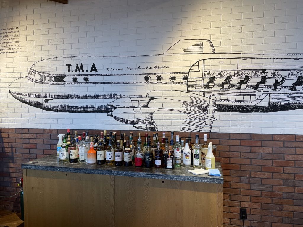 フォーポイントバイシェラトン名古屋 館内の壁に描かれた飛行機のイラストとドリンクカウンター