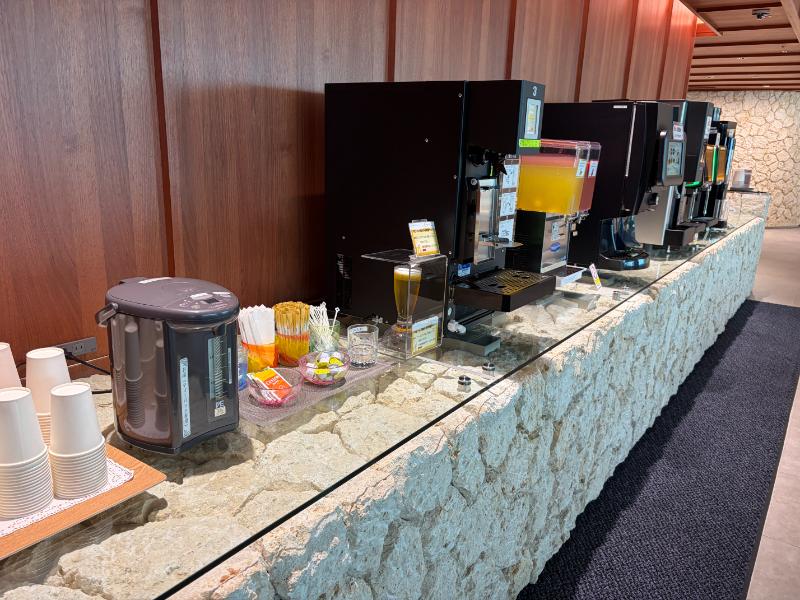 那覇空港ラウンジ華 コーヒーマシンとジュースディスペンサーが並ぶドリンクコーナー