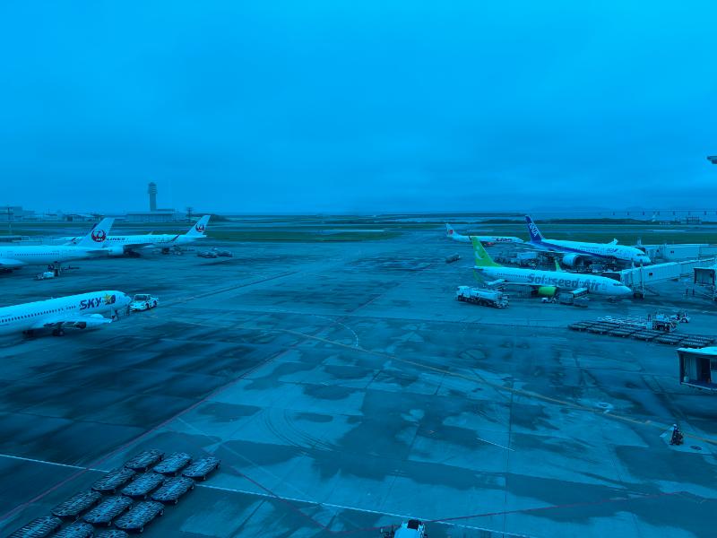 那覇空港ラウンジ華 4階の窓から見た夕暮れの滑走路と駐機中の旅客機